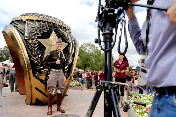 Student standing in front of an Aggie Ring