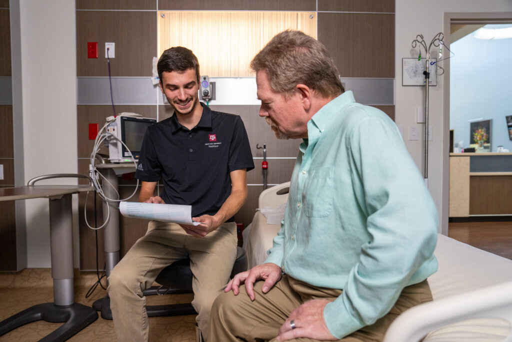 A man and a nutrition student sit in a clinical setting